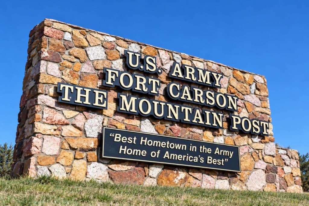 Fort Carson Mountain Post Sign - 5 Star Moving & Storage Stone U.S. Army sign at Fort Carson mounted on a colorful rock wall with a motto plaque beneath reading “Best Hometown in the Army Home of America’s Best.”